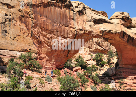 Hikers approach Hickman bridge in Capitol Reef National Park Stock Photo