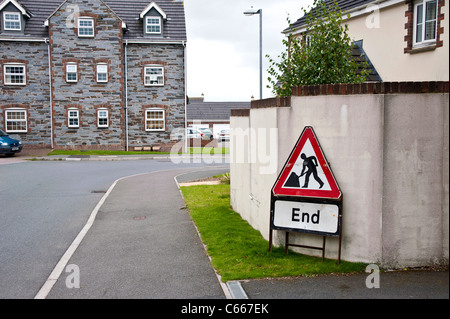 Rather battered temporary road works sign leaning against a wall in a residential neighbourhood neighborhood area estate Stock Photo