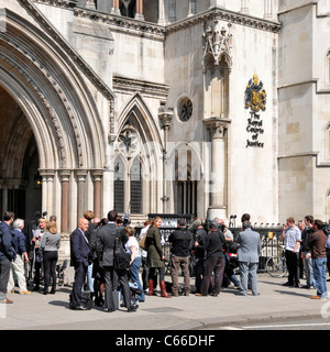 Crowd of media people including journalists reporters cameramen photographers & spectators on pavement at Royal Courts of Justice Strand London UK Stock Photo