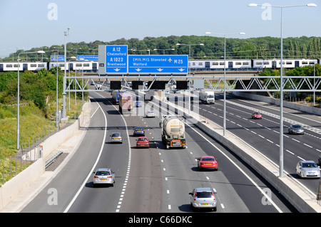 M25 motorway signs & railway bridge with Greater Anglia passenger Stock ...