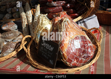Cured hams on market stall in market at Place d'Eglise, Larmor-Baden, Morbihan, Brittany, France Stock Photo