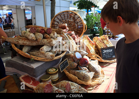 Boy looking  at sausages on market stall in market at Place d'Eglise, Larmor-Baden, Morbihan, Brittany, France Stock Photo