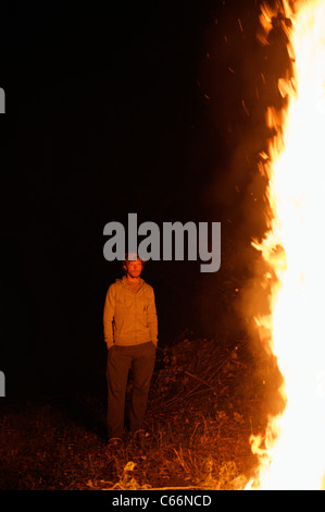 Man admiring campfire at night Stock Photo