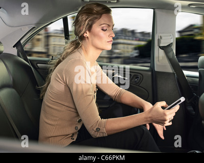 Woman using cell phone in car Stock Photo