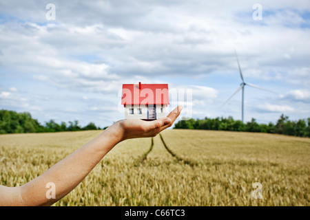 Woman with model house at wind turbines Stock Photo