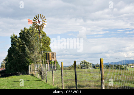 Sunshine Reflecting on a Water Pumping Windmill on Farmland Near Hamilton Waikato North Island New Zealand Stock Photo