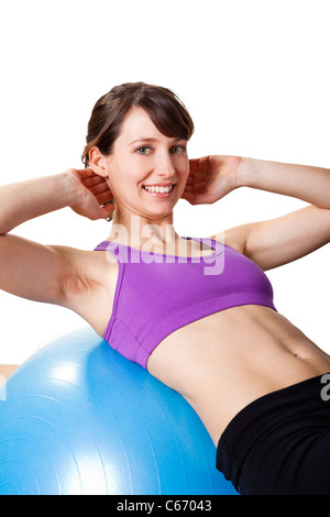 Beautiful young and athletic woman making exercises on a fitness ball Stock Photo
