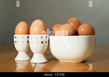 Two Boiled eggs with other eggs in a white bowl Stock Photo