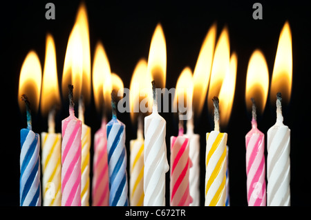Surreal image Close up of multiple candy colored lit birthday candles Stock Photo