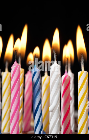 Surreal image Close up of multiple candy colored lit birthday candles ...