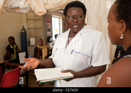 A nurse consults with a patient at a clinic in Kampala, Uganda, East Africa Stock Photo