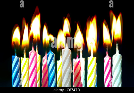 Surreal image Close up of multiple candy colored lit birthday candles Stock Photo