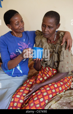 An elderly patient receives care in a hospital bed at Mulago Hospital in Kampala, Uganda. Stock Photo