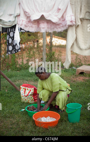 A woman washes clothing in Kampala, Uganda, East Africa. Stock Photo