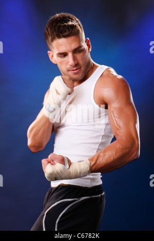 Toned boxer workng with hand wraps Stock Photo