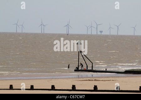 Frinton essex beach with groins and  Gunfleet Sands national grid wind turbines in north sea in background Stock Photo