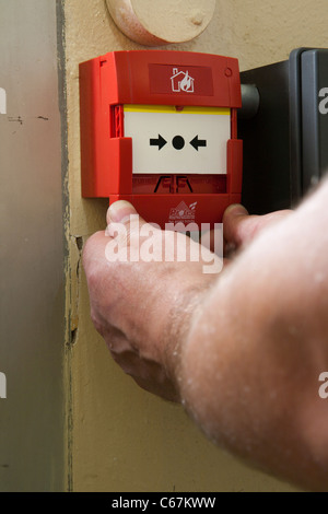 Qualified Electrician installing a Manual call point en 54 fire alarm callpoint Stock Photo