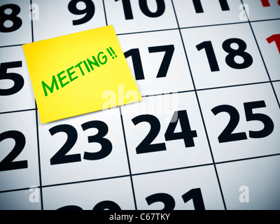 Meeting written on a sticky note on a calendar. Stock Photo