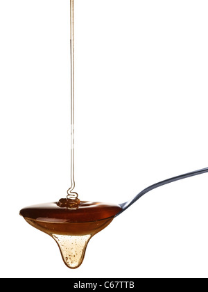 The honey slowly falls onto the spoon. Stock Photo