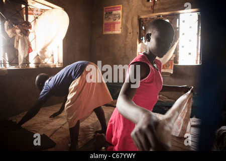 Children make their beds in a school dormitory in Amuria, Uganda, East Africa. Stock Photo