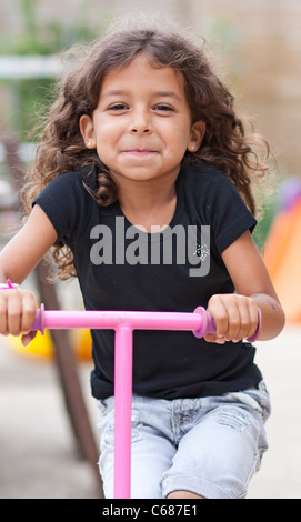 Smiling girl playing with a scooter Stock Photo