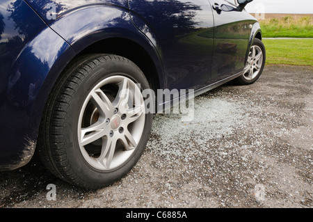 Broken glass underneath a car after its window is smashed by thieves Stock Photo