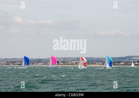 A row of small yachts with spinnakers up racing at Cowes week 2011 Stock Photo