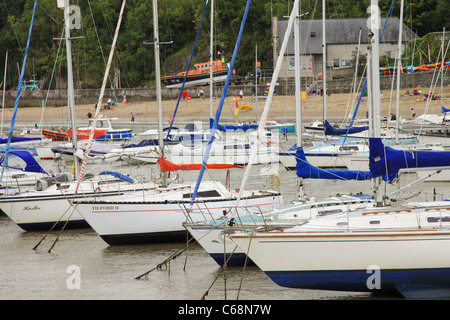 Sailing boats moored in front of RNLI lifeboat station in New Quay, Wales Stock Photo