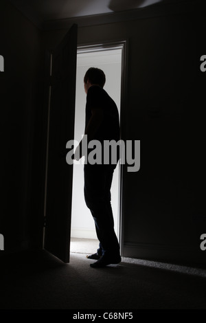 Silhouette of a man leaving a dark room Stock Photo - Alamy