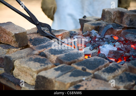 tongs with hot iron horseshoe in smith's hearth Stock Photo