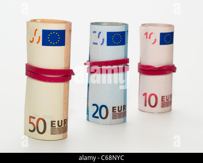 drei gerollte Geldbündel mit 10, 20 und 50 Euro-Scheinen | three rolled bundles of money with 10, 20 and 50 euros banknotes Stock Photo