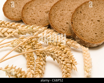 Brotscheiben, daneben liegen Weizenähren | slice of bread, alongside are wheat ears Stock Photo