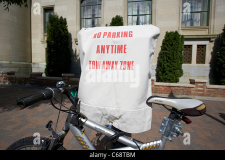 bike locked to no parking anytime tow away zone sign covering out of order parking meters Saskatoon Saskatchewan Canada Stock Photo