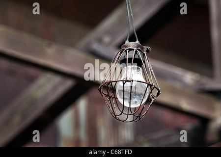 Dirty old light bulb in abandoned barn Stock Photo