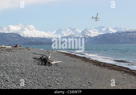 Float plane flying over an Alaskan beach on the Kachemak Bay Stock Photo