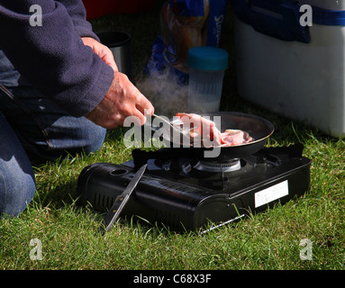 Cooking Bacon on an outdoor gas stove. Stock Photo
