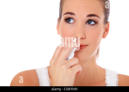 Attractive young woman using nasal spray. All on white background. Stock Photo