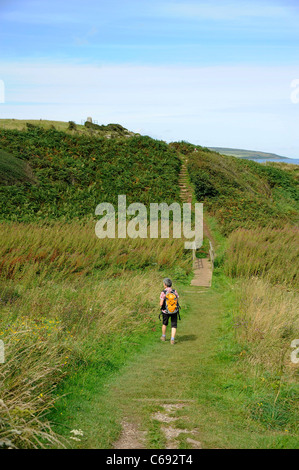 Rambler walks along coastal path in Moelfre, Anglesey, North Wales