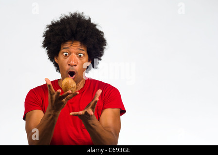 Guy dealing with a hot potato, a concept Stock Photo