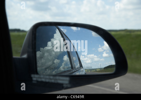 looking through window in sky reflected in car side mirror on yellowhead highway route 16 through Manitoba Canada Stock Photo
