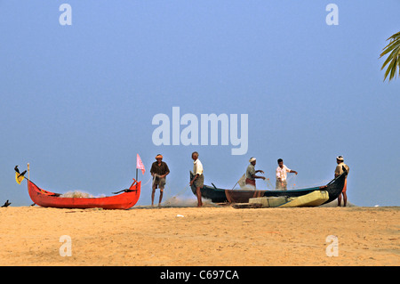 Fishermen sorting fishing nets on Marari Beach Kerala South India Stock Photo