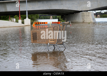 abandoned safeway shopping trolley in the red river in flood at the forks Winnipeg Manitoba Canada Stock Photo