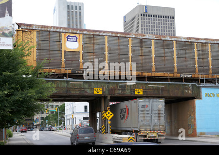 union pacific railway train passing over metal railroad bridge in downtown financial district Winnipeg Manitoba Canada motion Stock Photo