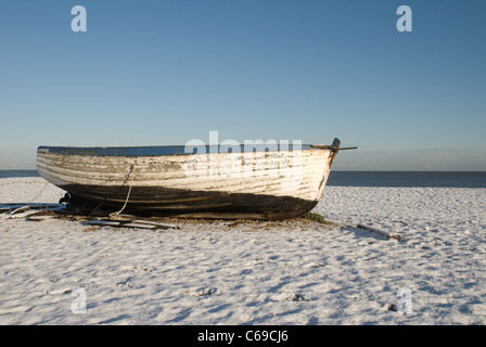 Fishing Boat on Aldeburgh Beach covered in snow. Stock Photo