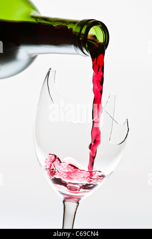 Red wine pouring to the broken glass Stock Photo