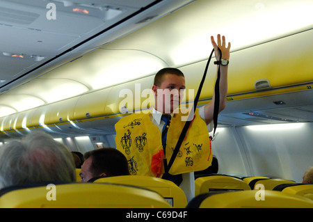 Steward showing safety informations at passengers of Ryanair Boeing 737 Stock Photo