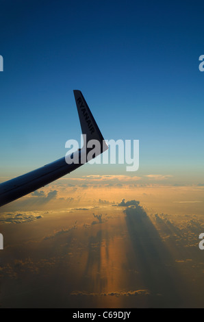 Wing tip of Boeing 737-800 airliner plane at sunset over Atlantic Ocean