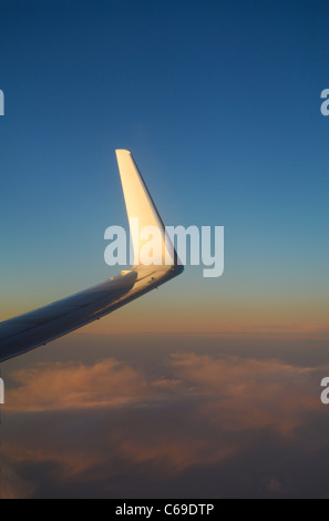 Wing tip of Boeing 737-800 airliner plane at sunset over Atlantic Ocean