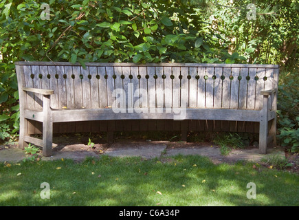 Curved Wooden Bench in Shady Garden Stock Photo