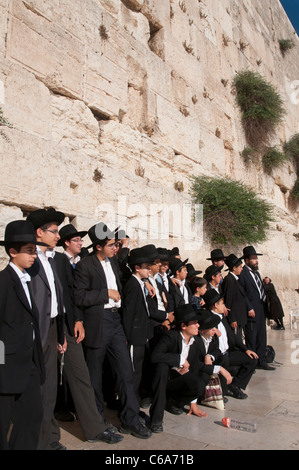 Group of young orthodox jewish men pausing in front of the western wall. Jerusalem. Israel Stock Photo